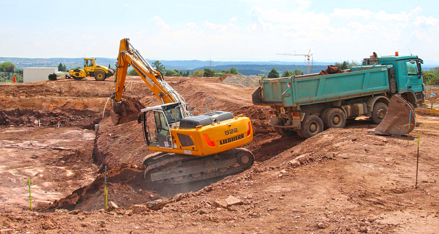 Bagger und LKW bei Aushubarbeiten.