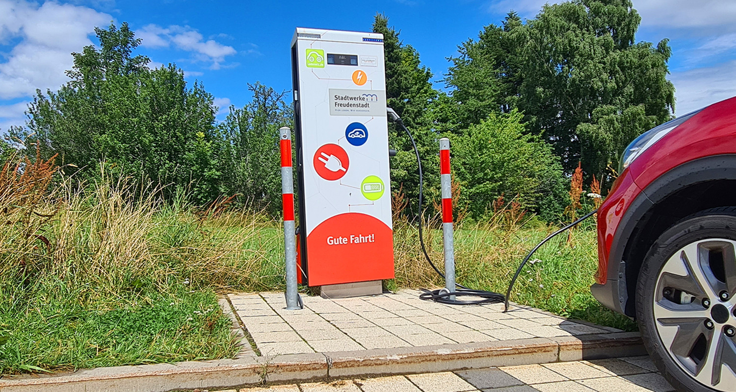 Elektrofahrzeug beim Ladevorgang an einer E-Lades&auml;ule.